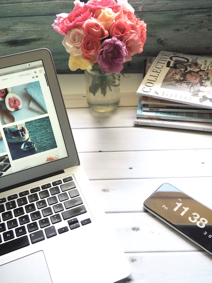 our-story Elegant workspace featuring a laptop, smartphone, and fresh roses in a bright setting.